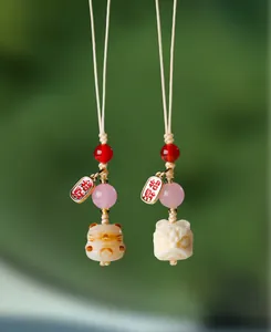 Vue détaillée de breloques lion et chat en Bodhi fait main avec perles d'agate rouge