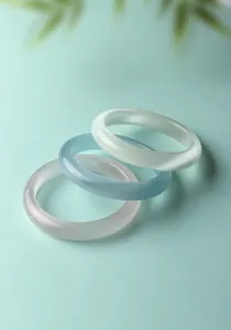 Gedetailleerde macroview van drie doorschijnende kattenoogsteen armbanden in kleur