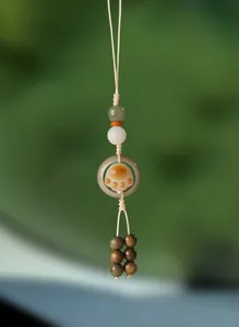 Gros plan d'un pendentif fait main avec un motif de patte de chat et des perles naturelles