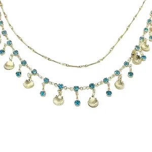 Detailweergave van de dubbellaagse gouden ketting met blauwe stenen en schelphangers