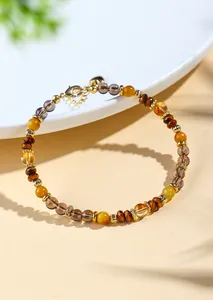 Nahaufnahme eines Perlenarmbands aus natürlichem Tigerauge und gelbem Kristall