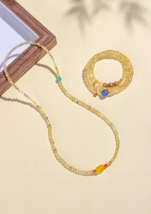 Vista detallada de collar y pulsera de cuentas de cuarzo rutilado dorado natural.