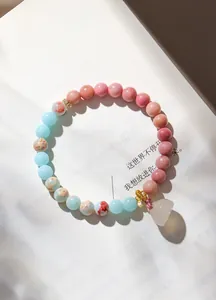 Detailansicht eines Natur-Rhodonit- und Achat-Perlenarmbands mit Lotus-Anhänger