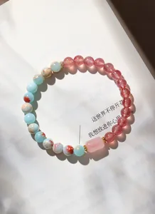 Nahaufnahme eines Armbands aus natürlichem Rosenquarz und Lotus-Achat Perlen