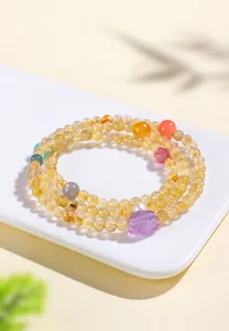 Vista detallada de pulsera de cuarzo rutilado dorado natural con toque de amatista