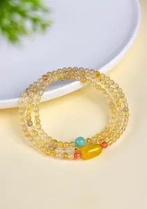 Vista detallada de la pulsera de tres hilos de cuarzo rutilado con cuenta de ágata amarilla