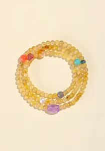 Detalle del collar de cuentas de cuarzo rutilado dorado natural con amatista y perlas