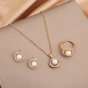 Primo piano di elegante set di gioielli placcati oro con perle bianche e strass