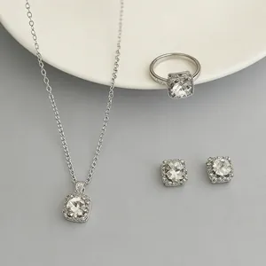 Elegante set di gioielli argentati con cristalli quadrati e dettagli di design halo