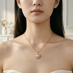Dettaglio di una collana con ciondolo a fiore di perla dorata sulla clavicola di una modella