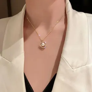 Vista dettagliata di un'elegante collana di perle dorate con ciondolo circolare in strass
