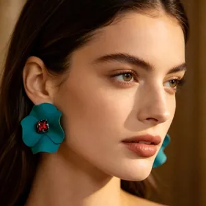 Dettaglio di orecchini a forma di fiore verde smeraldo opaco con gemma rossa quadrata.
