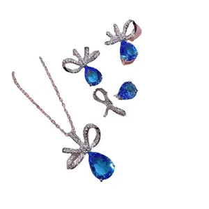 Elegante set di gioielli con cristalli blu a goccia e dettagli a fiocco brillanti e luminosi