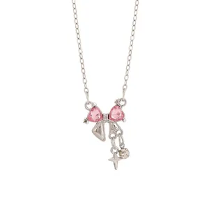 Macro view of a silver bow pendant necklace with pink heart crystals and star charm