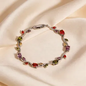 Dettaglio di un bracciale a forma di ramo di tulipano con zirconi colorati su seta