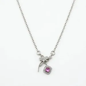 Détail exquis d'un collier nœud argenté avec pendentif zircon rose carré et pierres claires