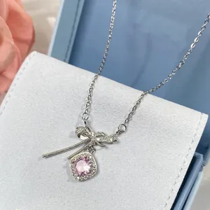 Gros plan sur un collier nœud élégant avec pendentif en pierre rose carrée