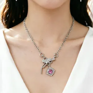 Gros plan détaillé d'un élégant collier à nœud avec un pendentif en zircon rose sur le cou.