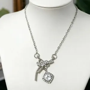 Gros plan du pendentif en zircon carré étincelant et du nœud sur le collier argenté