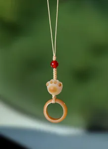 Vue détaillée d'un pendentif patte de chat en Bodhi avec une perle rouge et anneau