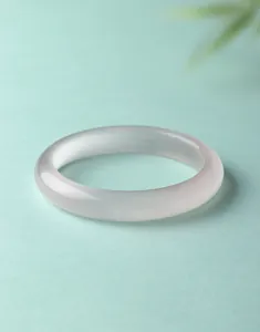 Macro-opname van een doorschijnende witte kattenoogsteen armband met zijdeachtige glans