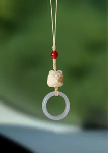 Vue détaillée d'un pendentif lion chinois avec anneau en agate violette et perle rouge