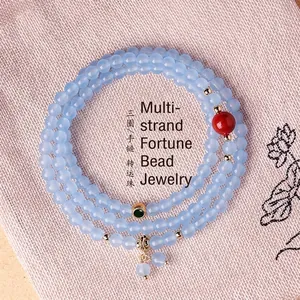 Elegante drievoudige wikkel lichtblauwe kralenketting en armband met rood en groen