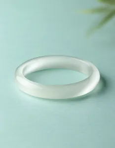 Gedetailleerd overzicht van een witte kattenoogsteen armband met gladde afwerking