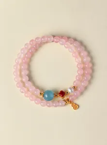 Détail rapproché d'un bracelet en quartz rose avec une gourde dorée en argent S925