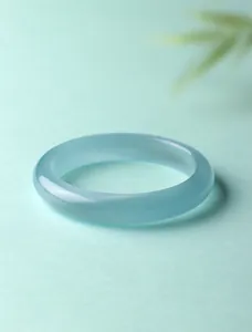Detailopname van een gladde, doorschijnende lichtblauwe kattenoogsteen bangle armband.