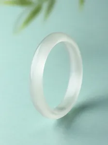 Gedetailleerde weergave van een witte kattenoogsteen armband met verticaal lichteffect.