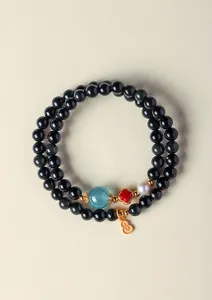 Vue détaillée d'un bracelet à deux rangs de perles noires avec un pendentif gourde