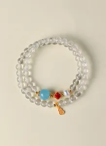 Gros plan sur un bracelet en perles de cristal naturel avec un pendentif gourde en argent