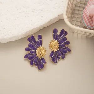 Dettaglio di eleganti orecchini a margherita viola e oro in stile retrò francese classico
