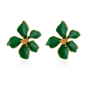 Vista macro di orecchini a fiore in smalto verde con eleganti dettagli con bordo oro