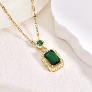 Dettaglio macro di una collana vintage con ciondolo in cristallo verde smeraldo e oro