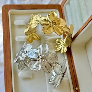 Primo piano di bracciali a polsino con fiori dorati e argentati in una scatola