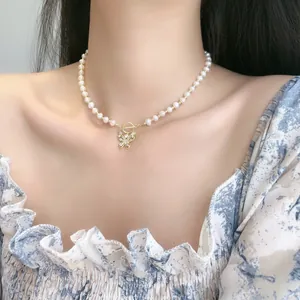 Elegante collana con ciondolo a farfalla, perle bianche e chiusura OT dorata raffinata