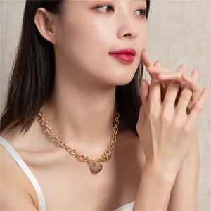 Dettaglio di una donna elegante che indossa una collana a catena con cuore d'oro.