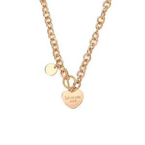 Primo piano di una collana a catena dorata con ciondolo a cuore "Love you more".