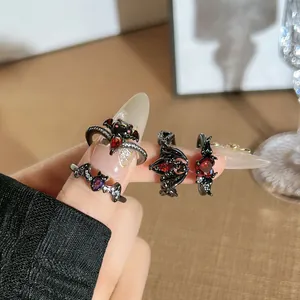 Detailed view of Gothic bat demon wing open rings set featuring red and purple gemstones