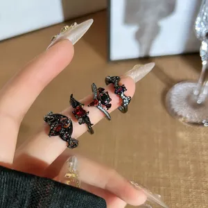 Close-up of gothic dark bat and demon wing rings with red crystals worn on fingers
