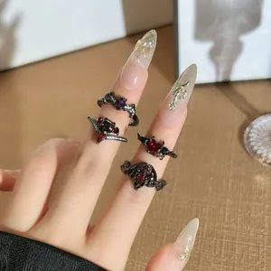 Detailed macro view of gothic black bat and devil wing rings with red rhinestones