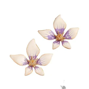 Primo piano di orecchini a fiore a cinque petali sfumati viola e bianco dorati