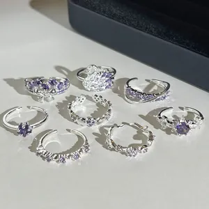 Gros plan de bagues argentées réglables avec pierres violettes et motif de cygne