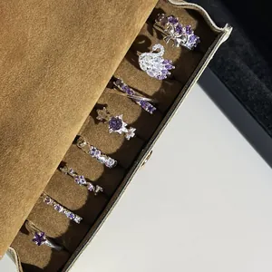 Vue détaillée de bagues élégantes en cristal violet avec motifs de cygne et nœud.