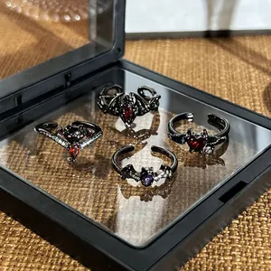 Detailed close-up of Gothic black bat and demon wing rings presented in a display box