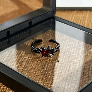 Detailed view of gothic black demon wings adjustable ring with a red heart stone