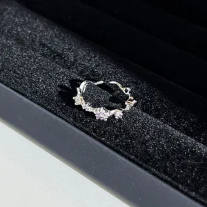 Gros plan détaillé d'une bague argentée ornée de cristaux violets et d'un nœud
