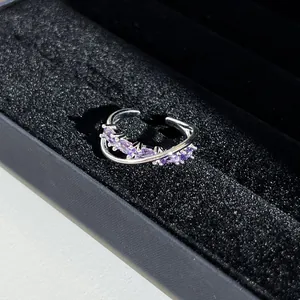 Vue macro d'une élégante bague croisée aux pierres violettes dans un écrin en velours